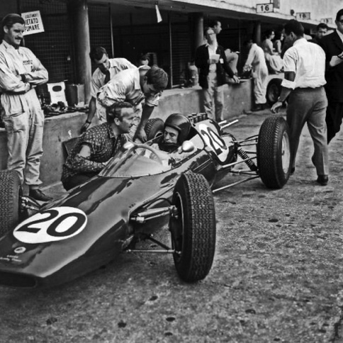 A Monza, Conciliabule entre colin Chapman et Jim Clark sous l'oeil de Graham Hill A Monza, Conciliabule entre colin Chapman et Jim Clark sous l'oeil de Graham Hill